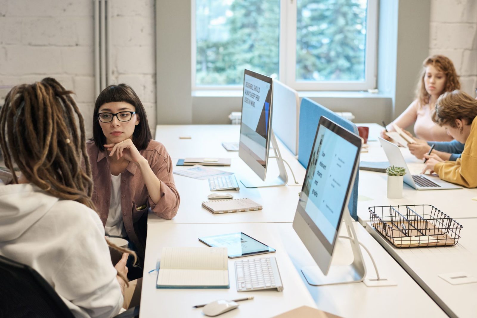 Two colleagues talking at an open plan desk