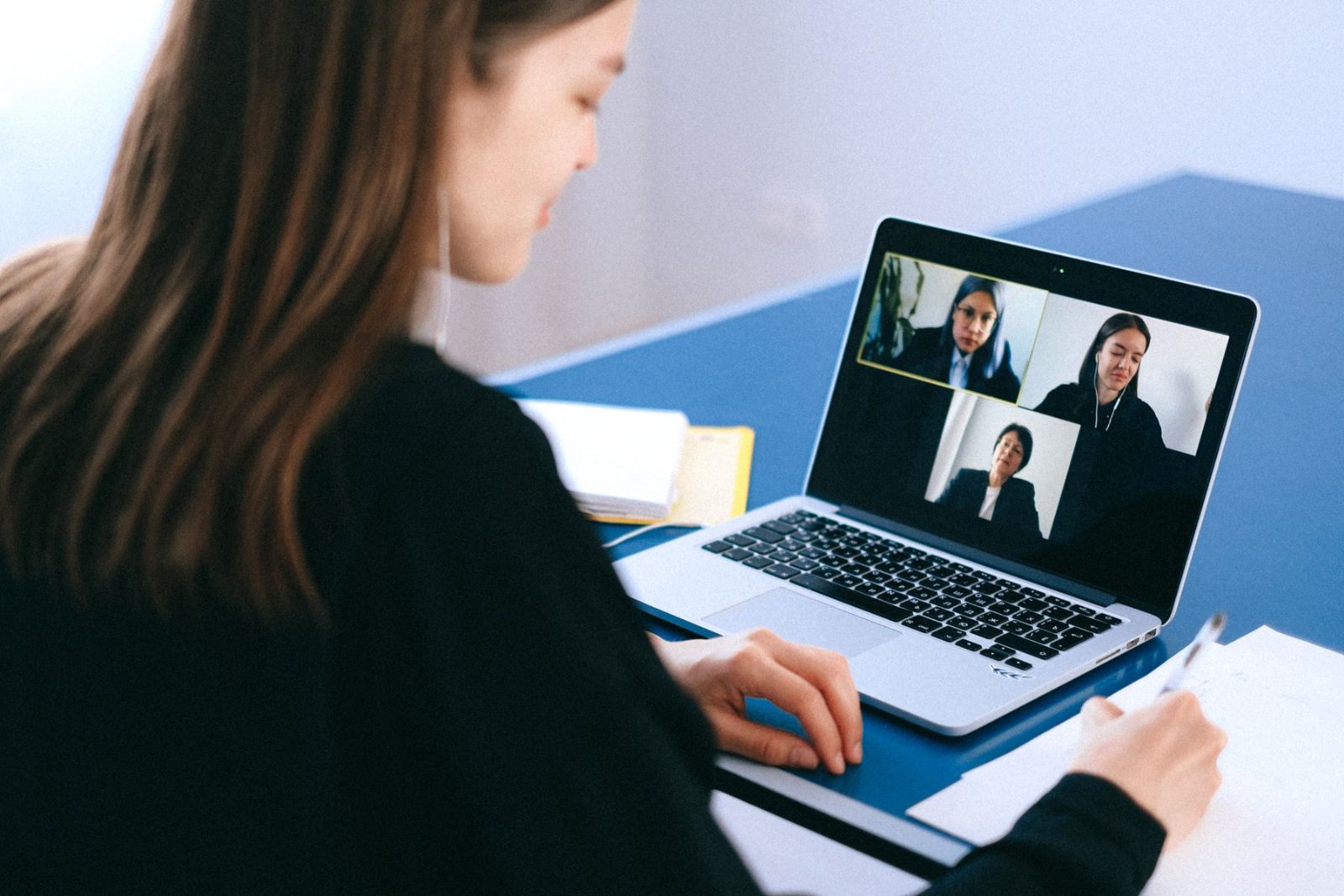A laptop showing a video call with several people