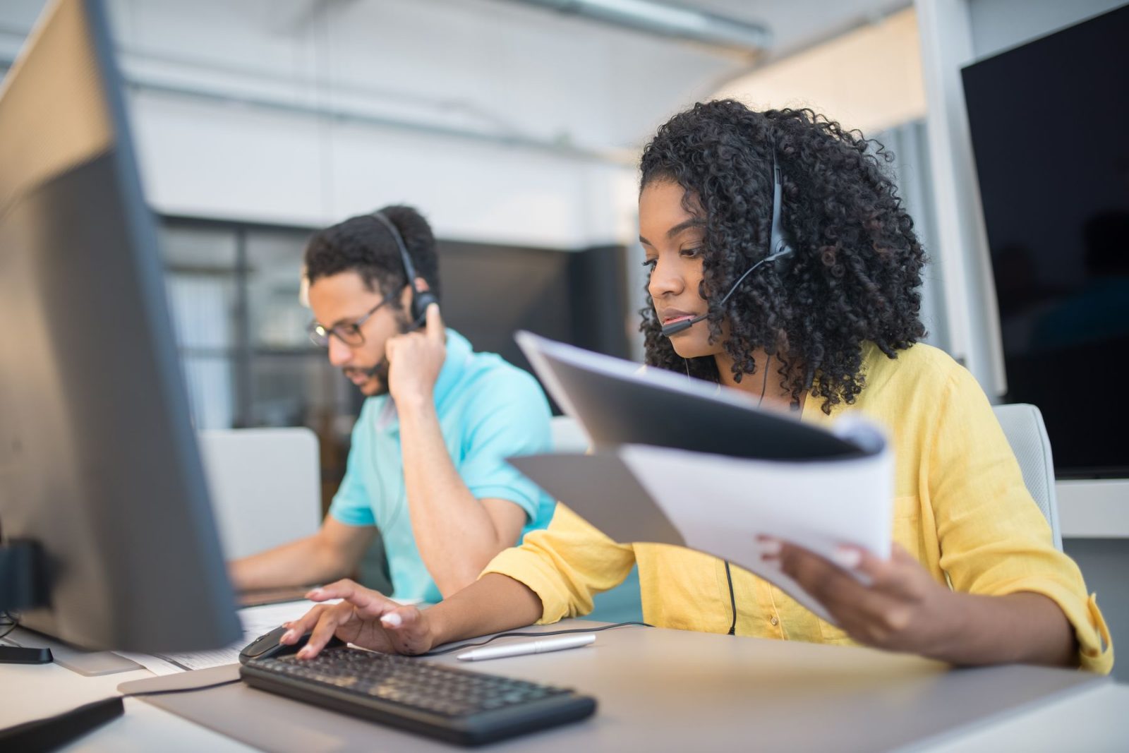 Two colleagues checking a document together at a workstation