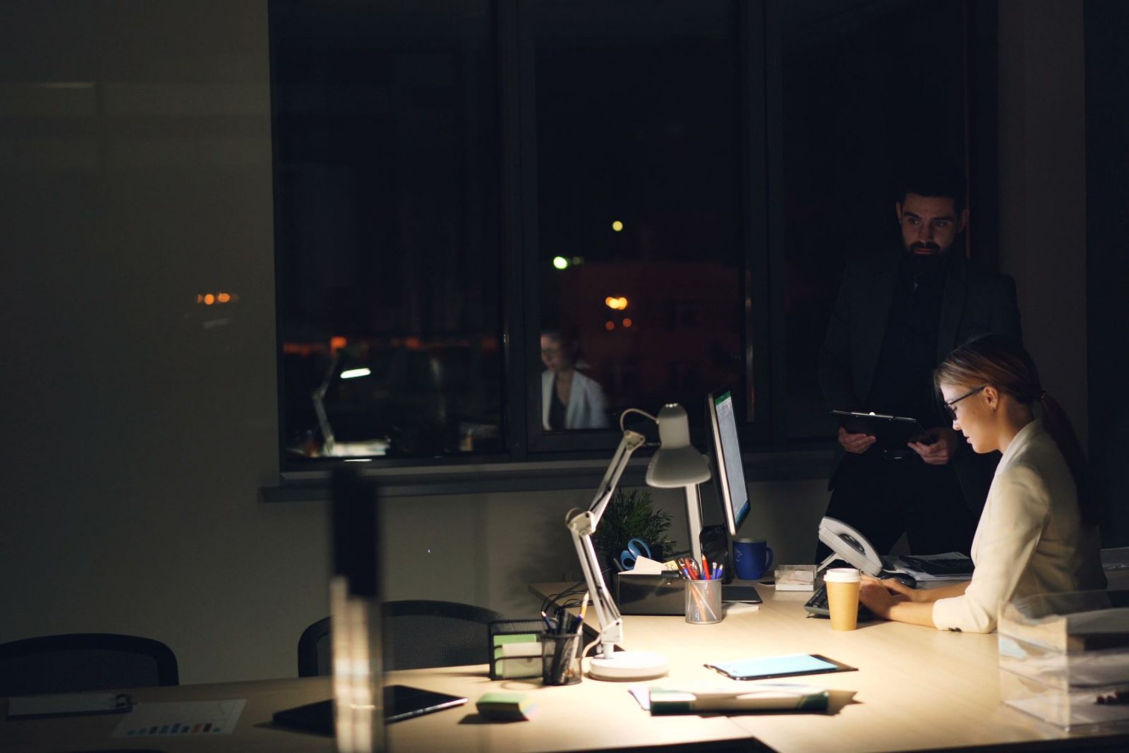 A dimly lit office with one person still working