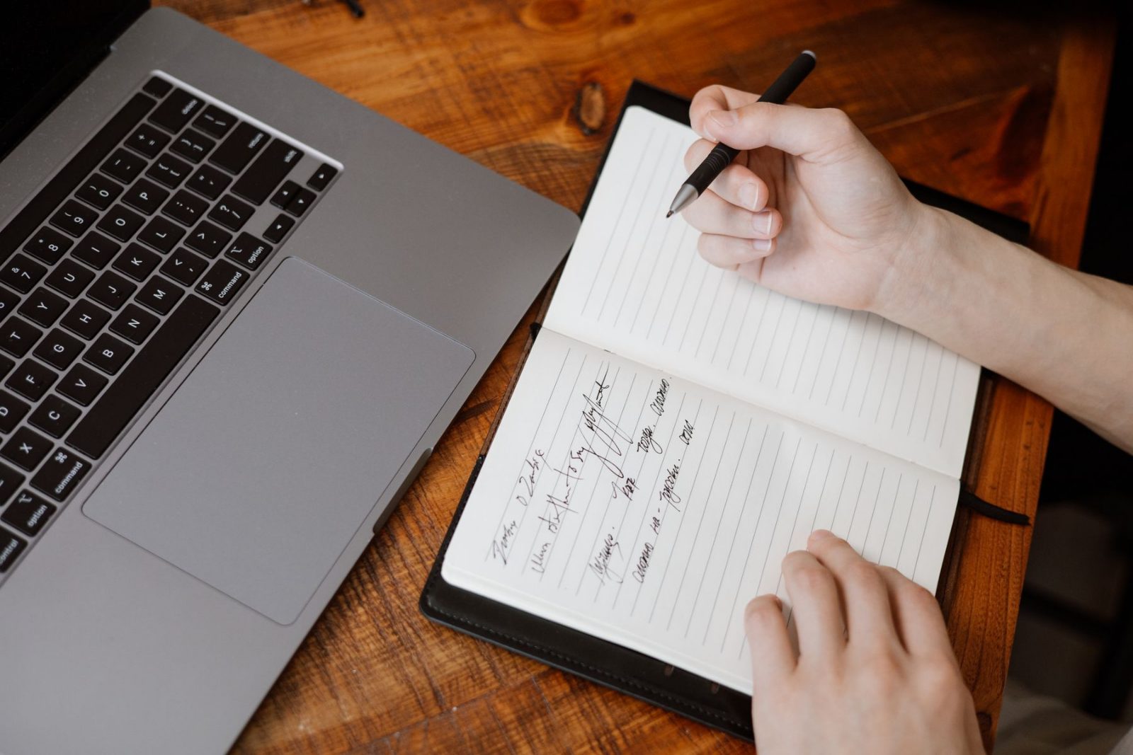 Handwritten notes beside an open laptop