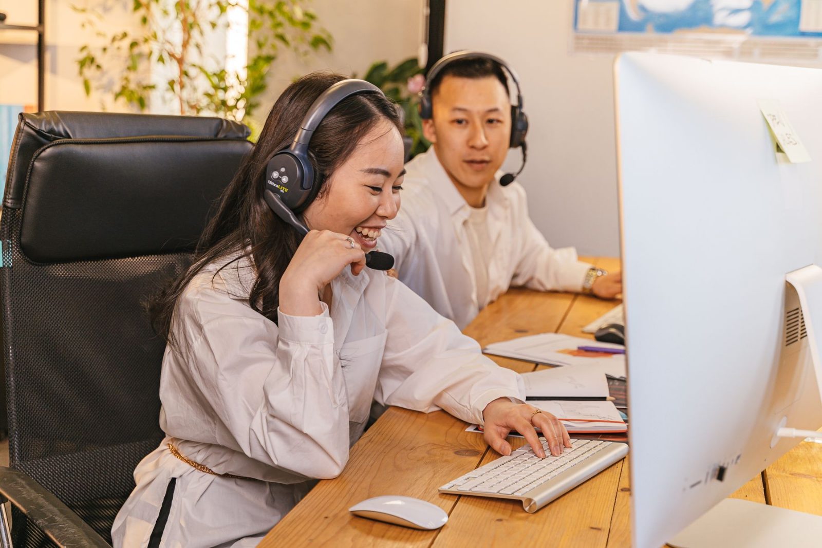 Two colleagues working side by side at headset workstations