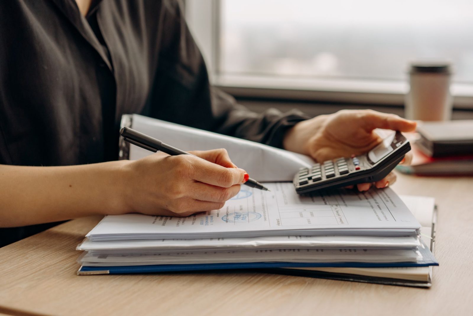 An accountant working through ledgers and a calculator at a desk