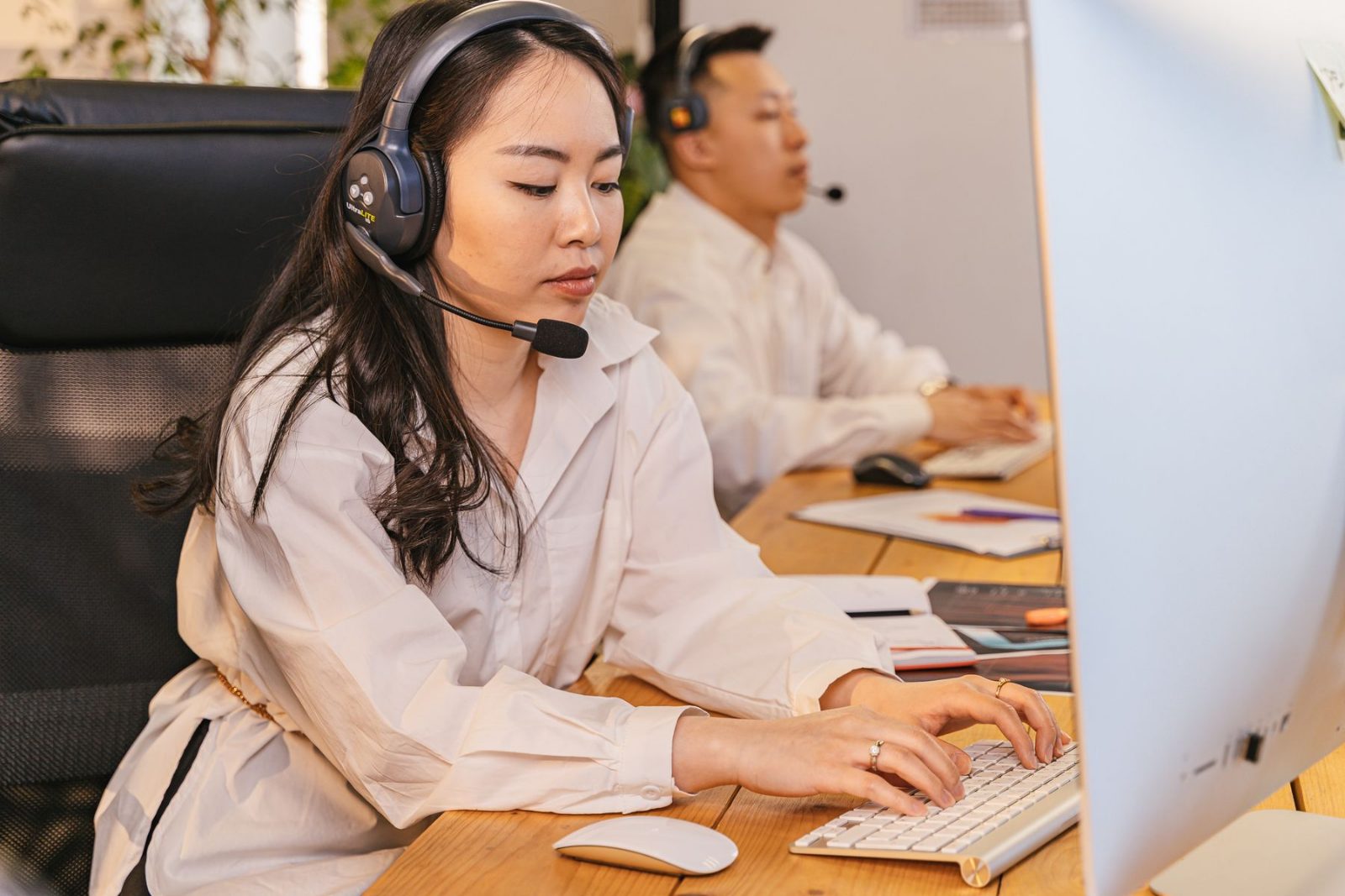 A customer service professional at a headset workstation