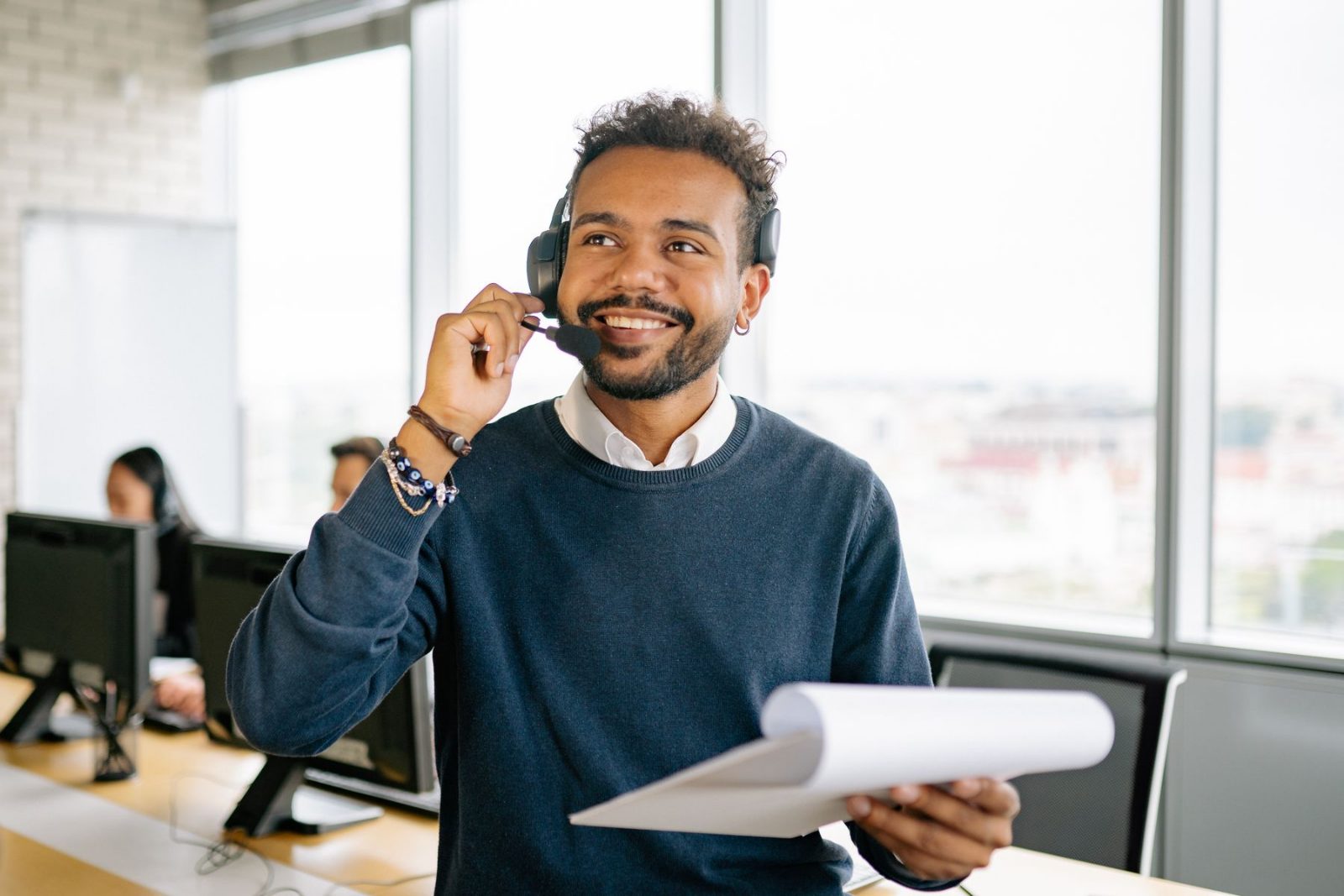 An agent taking a headset call beside an office window
