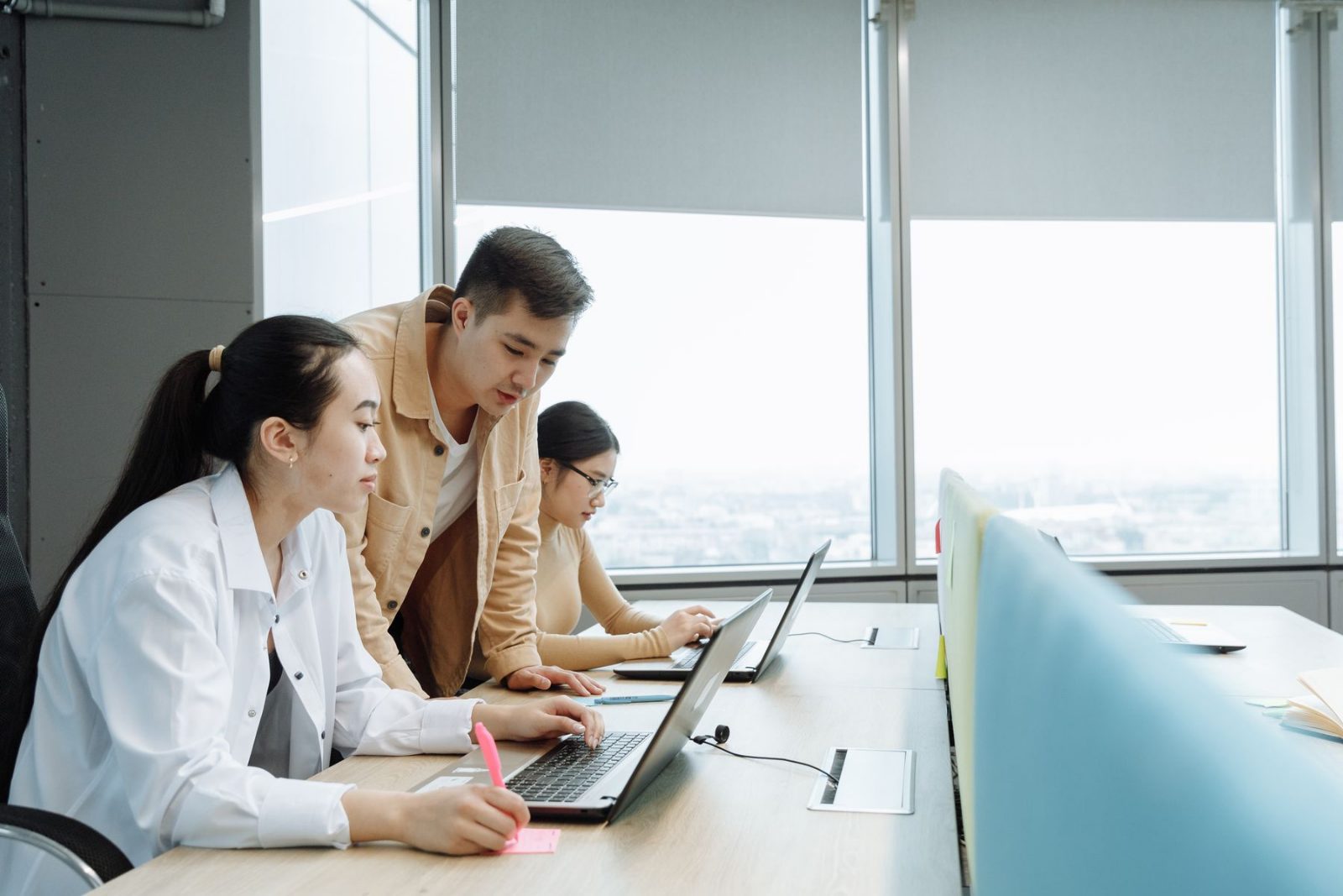 Colleagues working together at adjacent screens